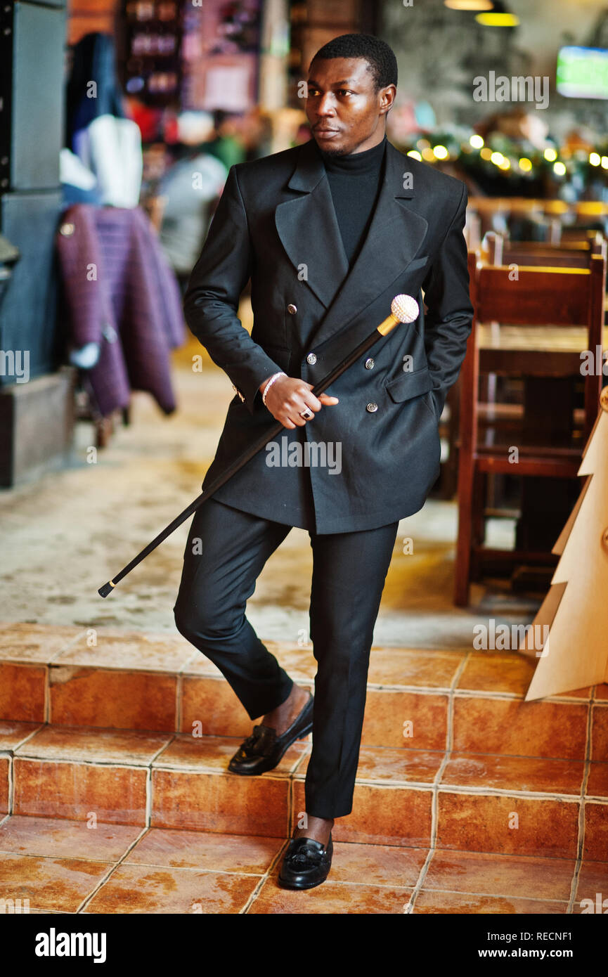 Stylish african american gentleman in elegant black jacket, holding