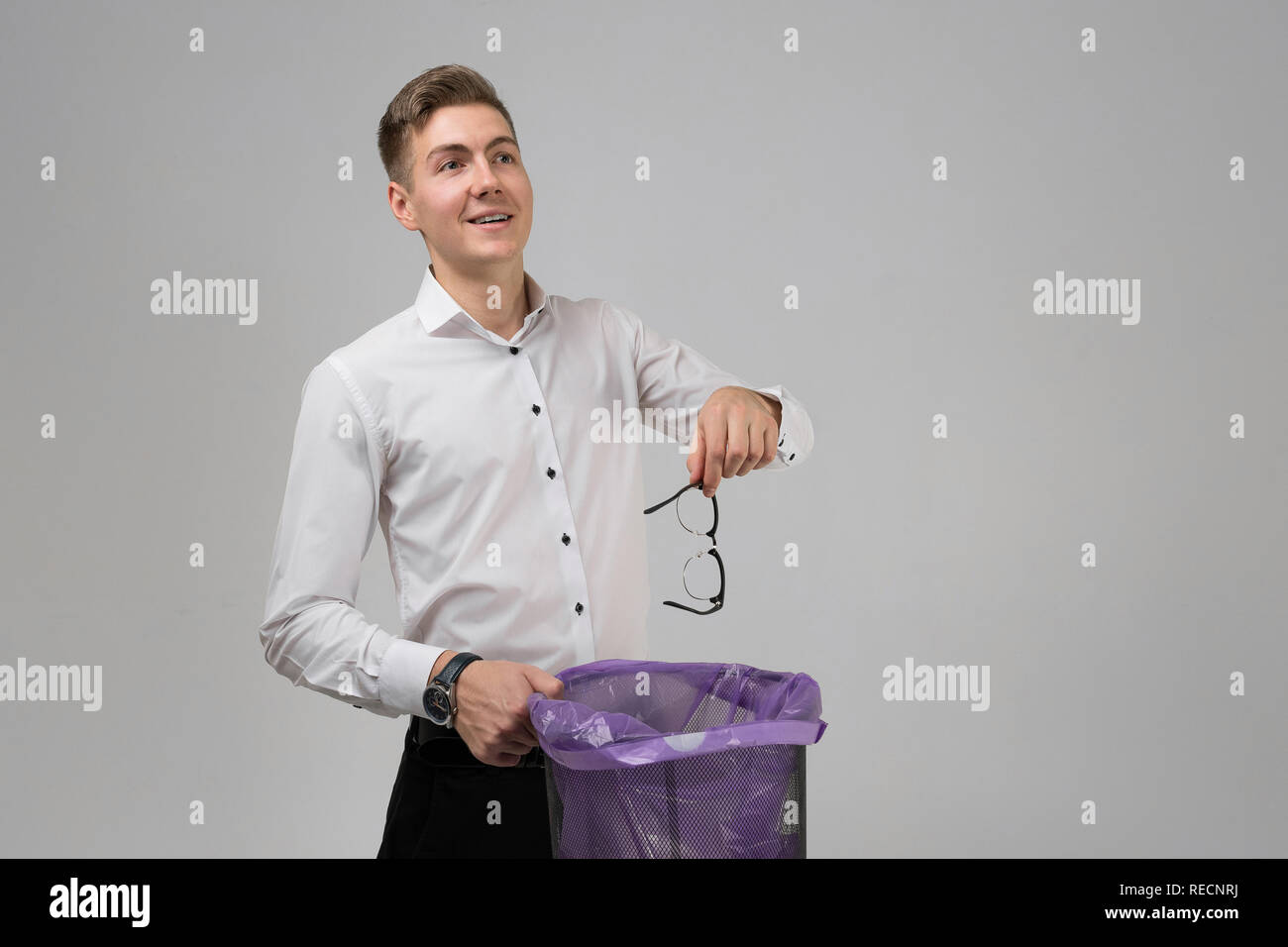 Young man throws glasses in trash isolated on white background Stock
