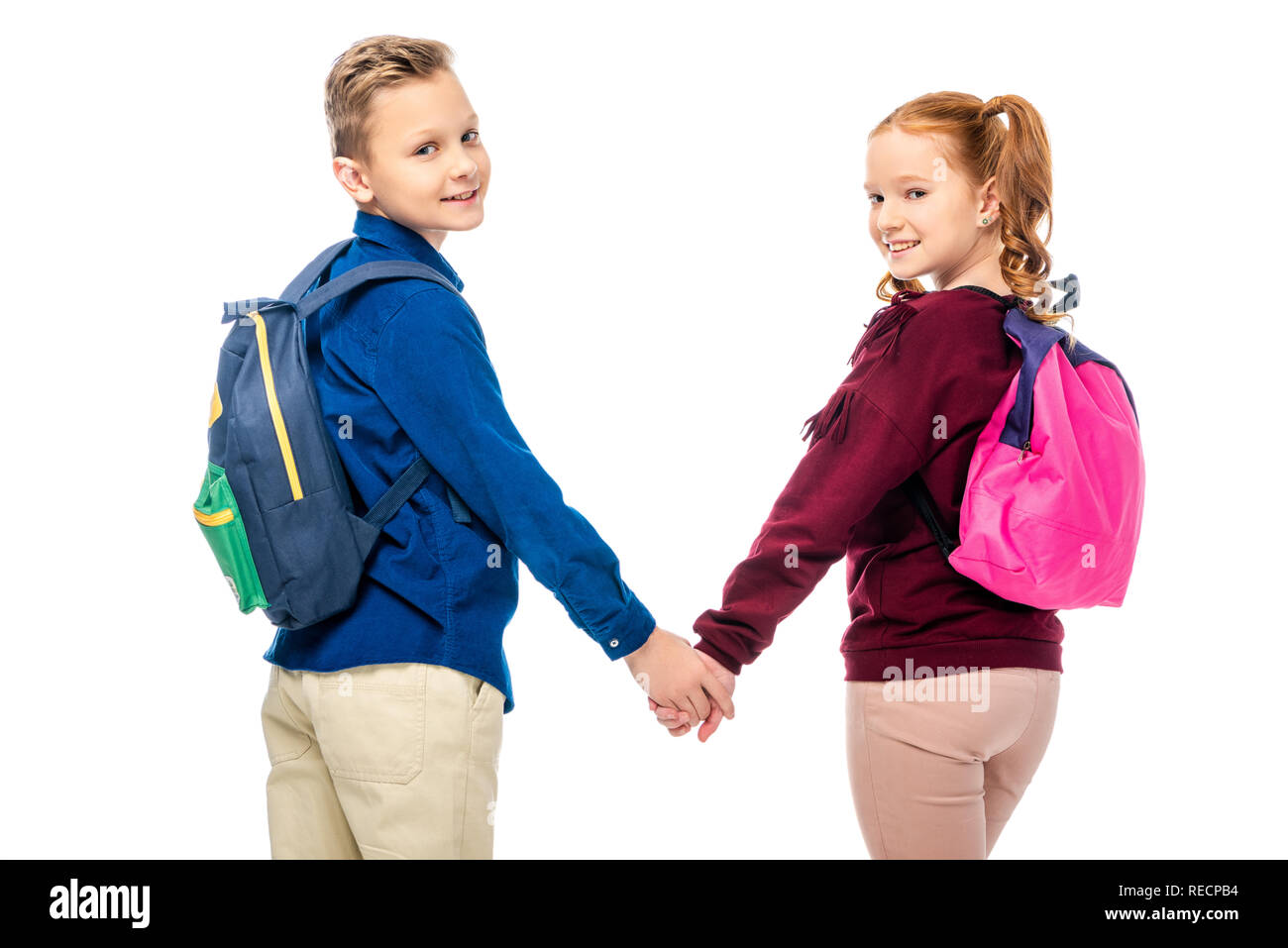 schoolkids holding hands and smiling at camera isolated on white Stock Photo