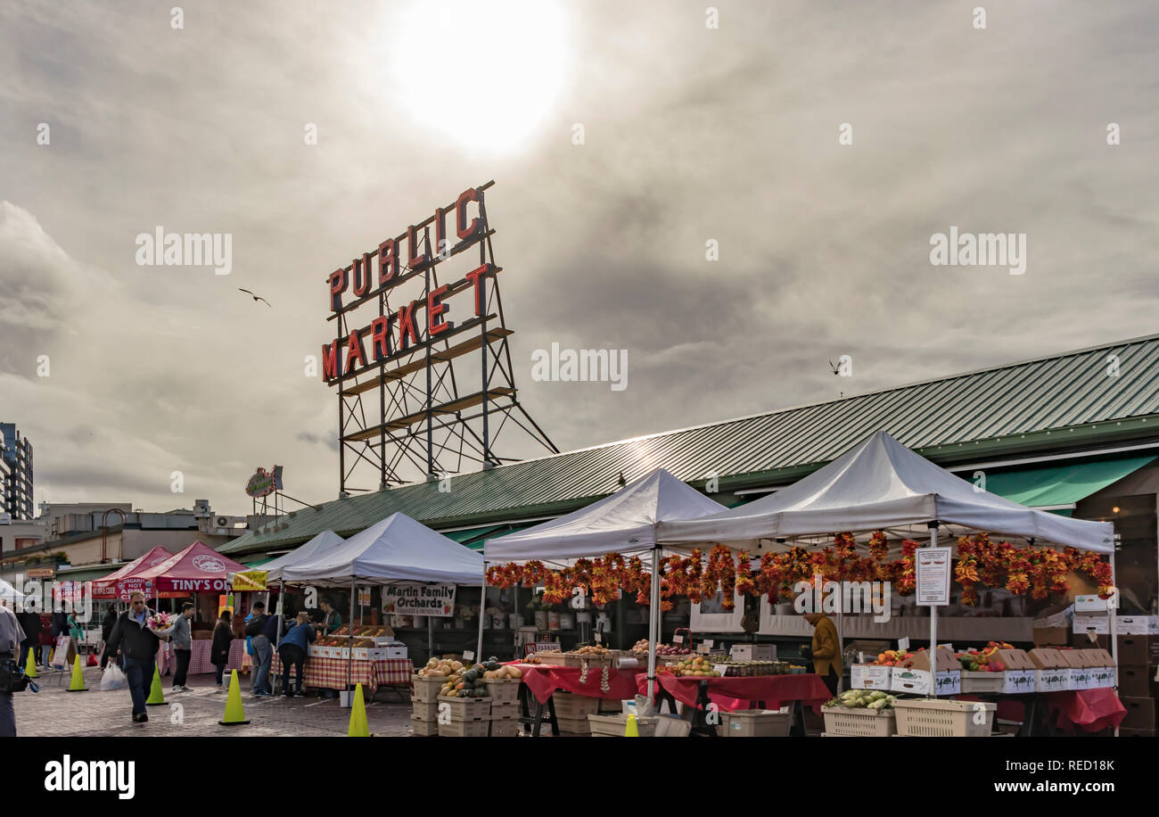 Seattle, Washington, USA - 28 October 2018. The sun shines through clouds above the Farmers Market at Pike Place Market in Downtown Seattle. Stock Photo