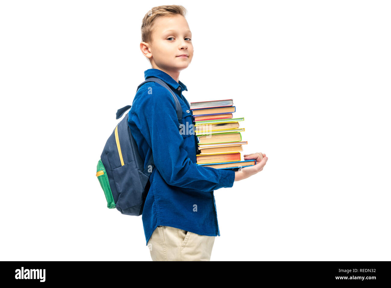 cute boy holding stack of books and looking at camera isolated on white Stock Photo