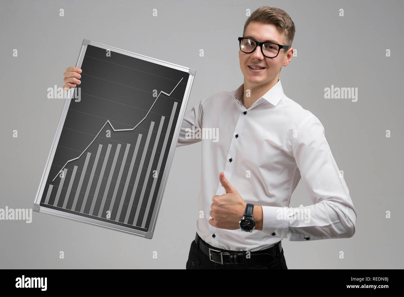 Young man shows class sign and keeps rising graph isolated on white ...