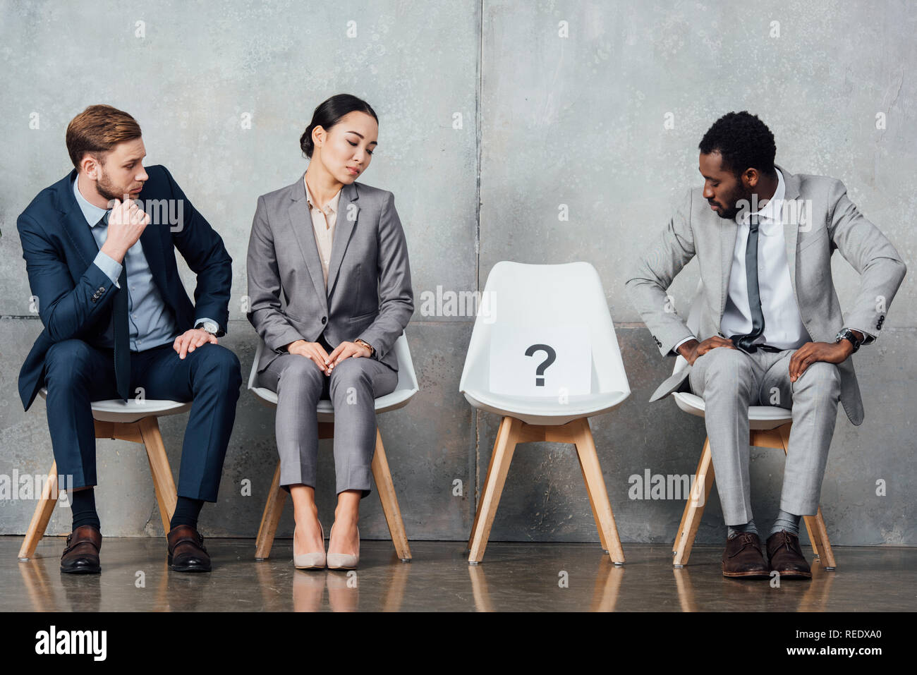 Waiting Questions multiethnic businesspeople looking at card with question mark on chair ...