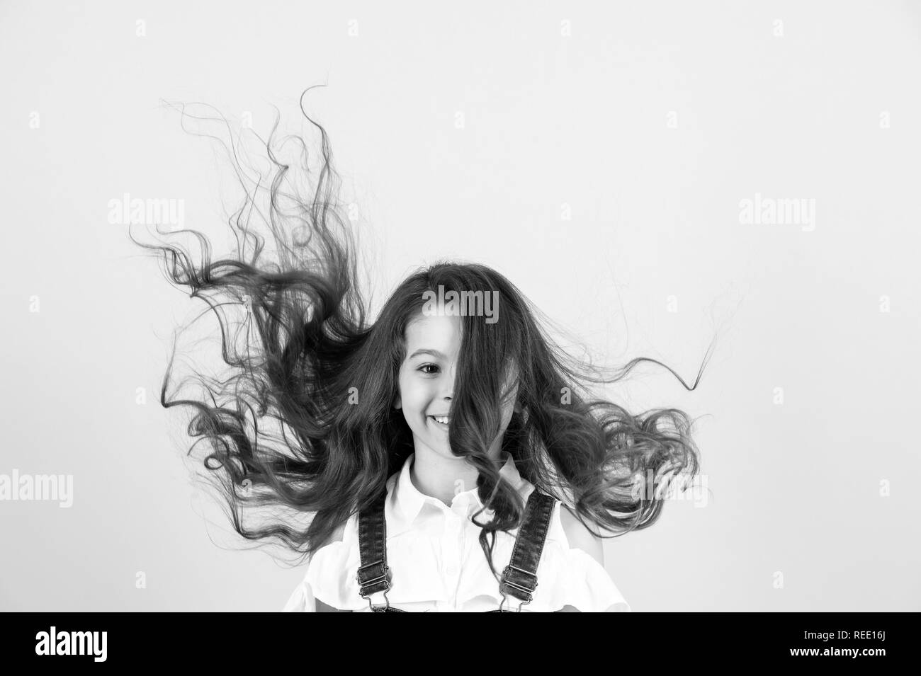 Hair style, care concept. Happy kid with long healthy brunette hair blowing  on blue background, copy space Stock Photo - Alamy