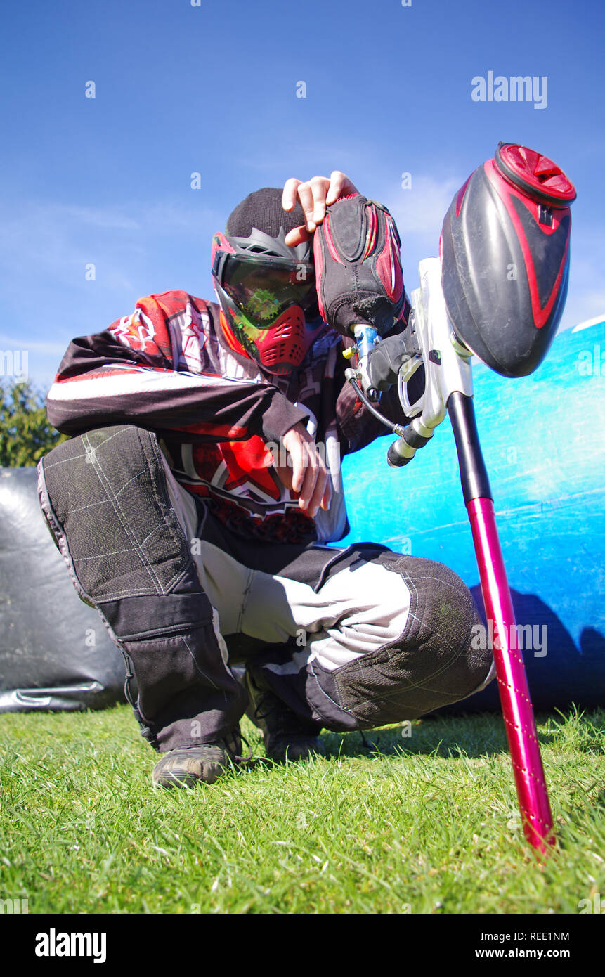 Paintball sport player with splatter on his mask. Depressed paintball sport player after defeat. Competition extreme sport failure Stock Photo