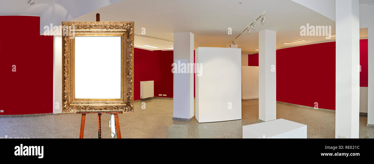 Painter's easel and empty antique golden frame in a exhibition gallery