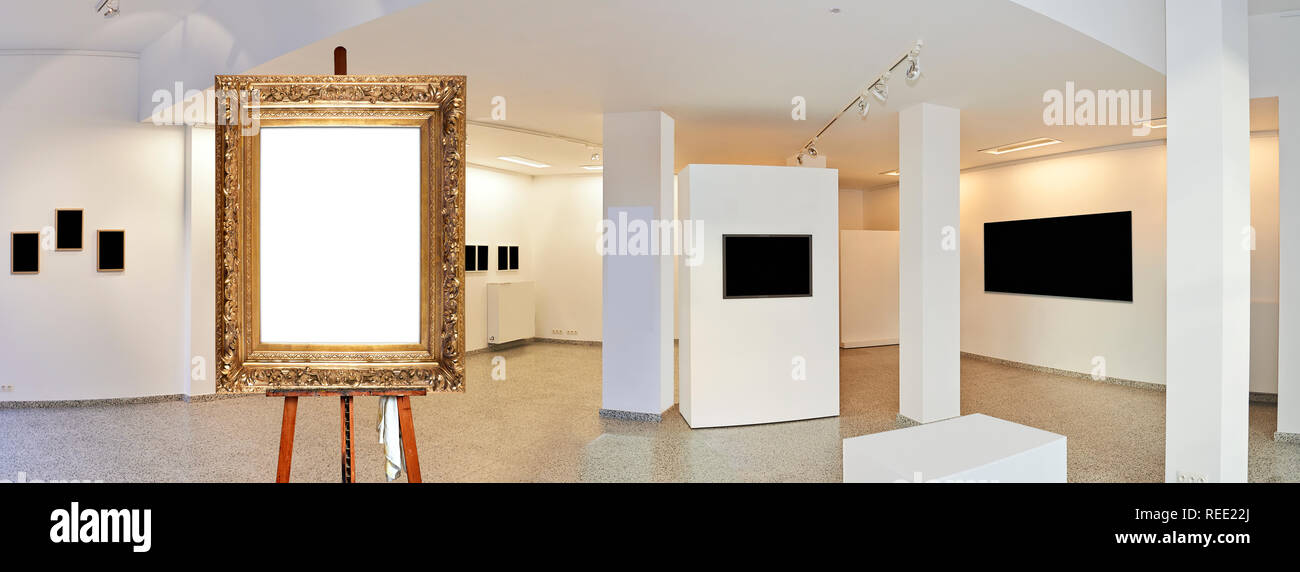 Painter's easel and empty antique golden frame in a exhibition gallery