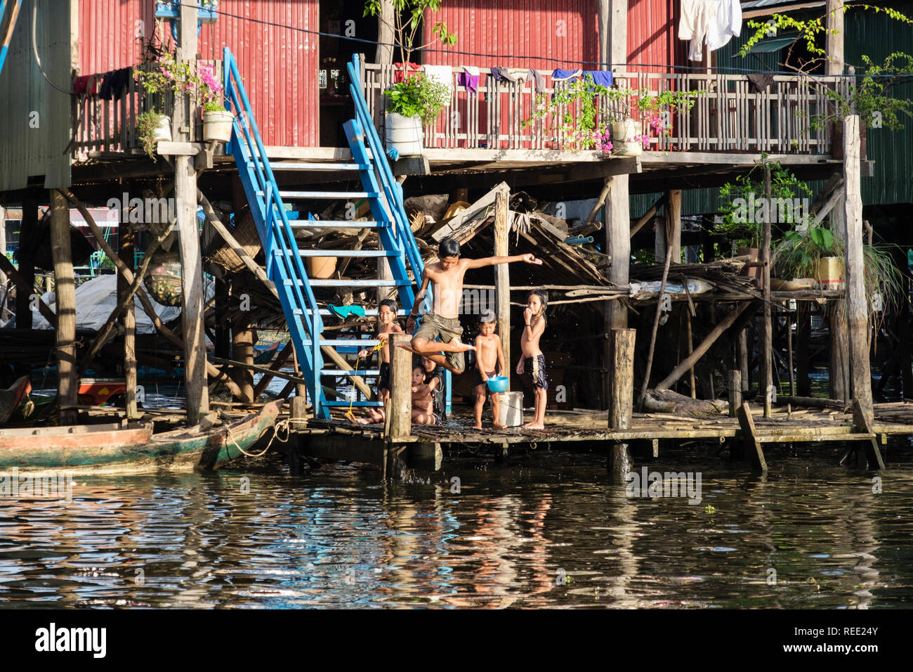 Children playing outside a house on stilts in floating village in Tonle Sap lake. Kampong Phluk, Siem Reap province, Cambodia, Asia Stock Photo