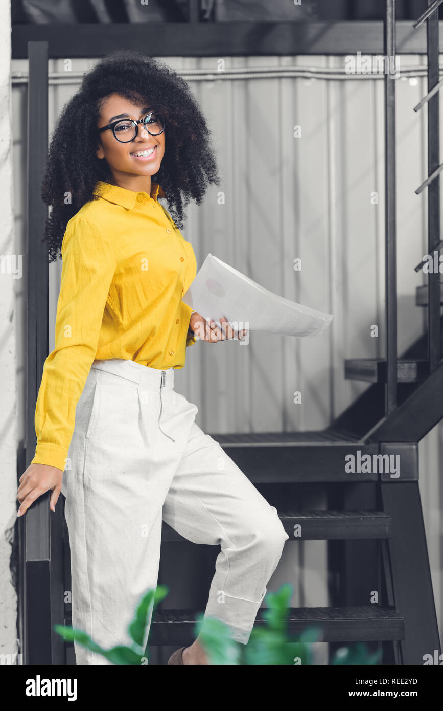 attractive young african american businesswoman holding papers and ...