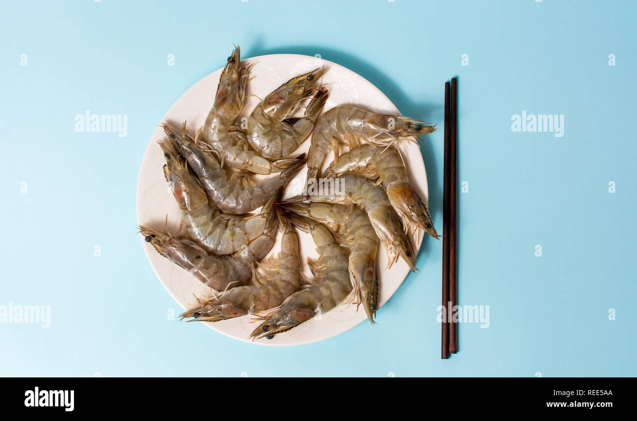Raw shrimps on a plate flat lay top view Stock Photo - Alamy
