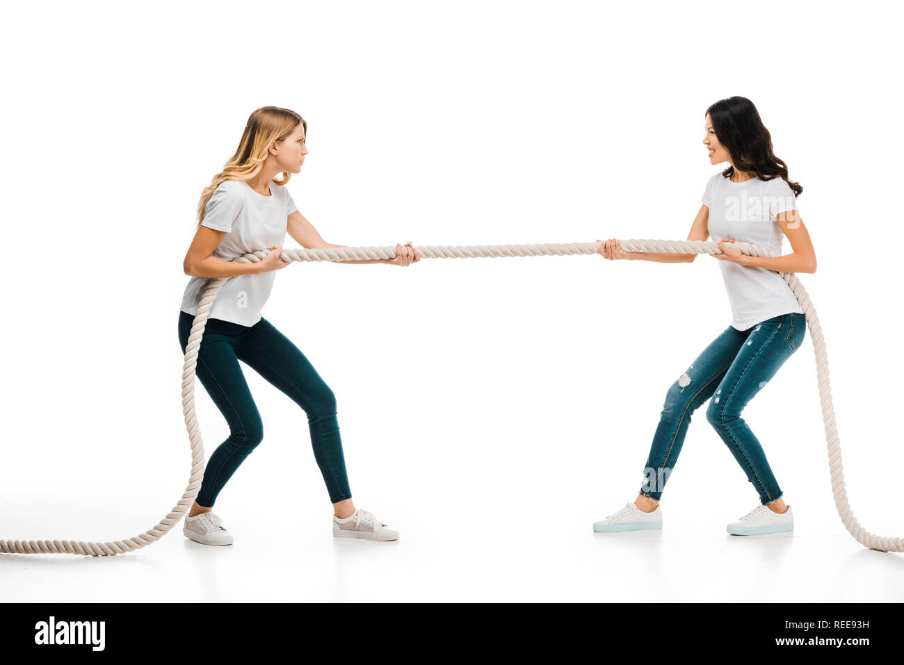 angry young women pulling rope and looking at each other isolated on white  Stock Photo - Alamy