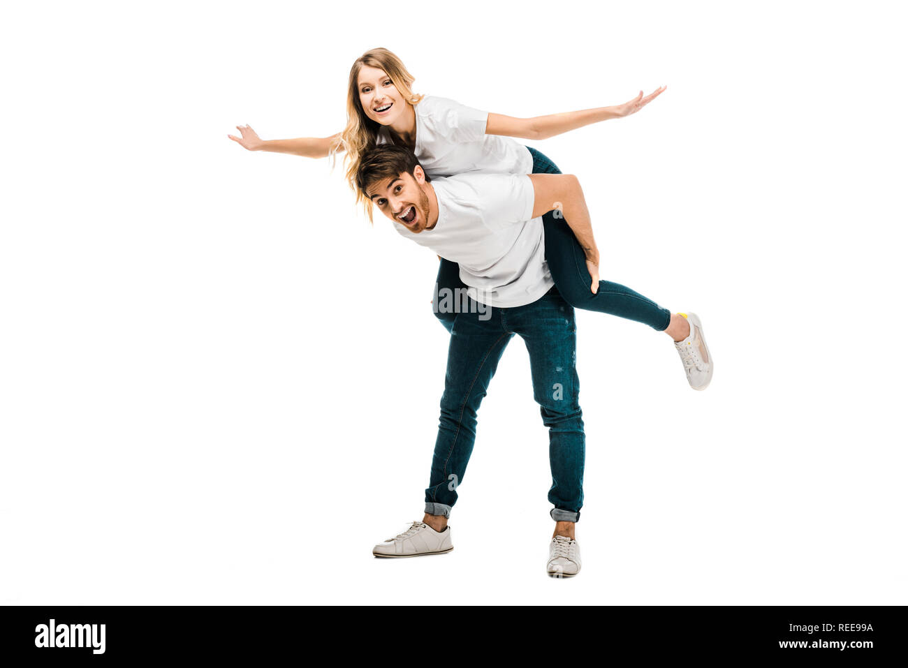 cheerful young couple piggybacking and smiling at camera isolated on white Stock Photo