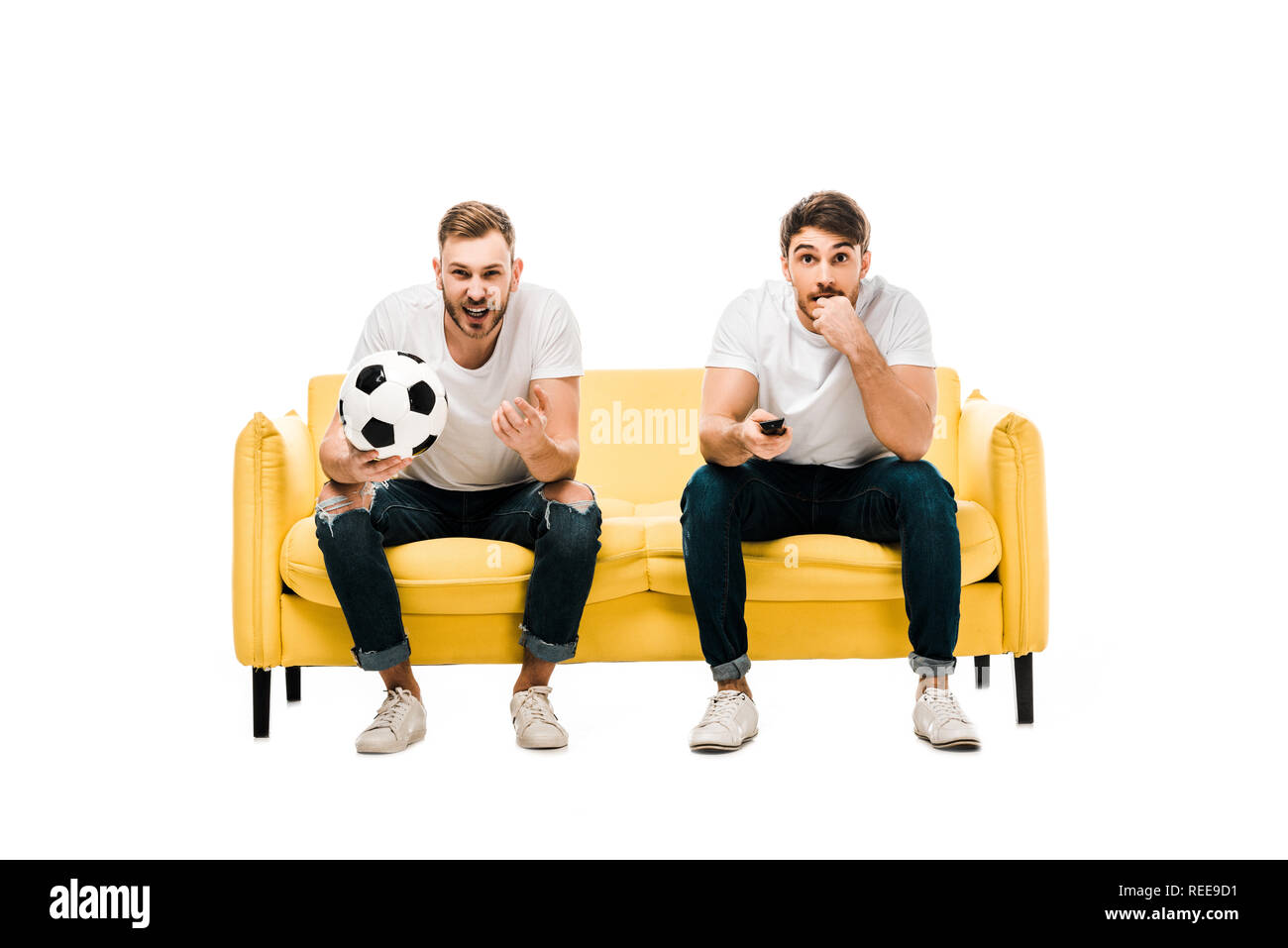 Emotional Young Men With Soccer Ball Sitting On Couch And Watching