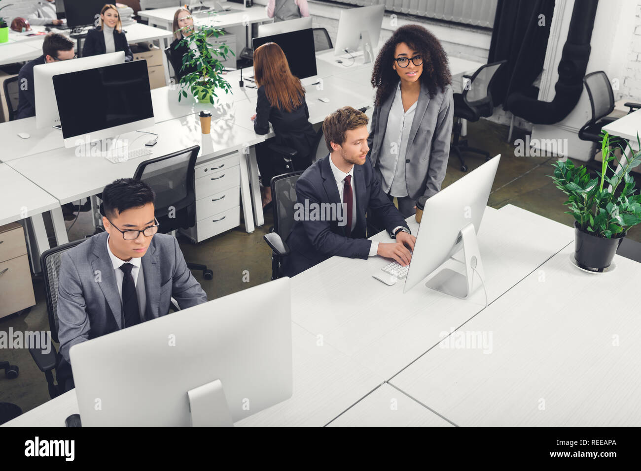 Adult men sitting at desktop computers hi-res stock photography and ...