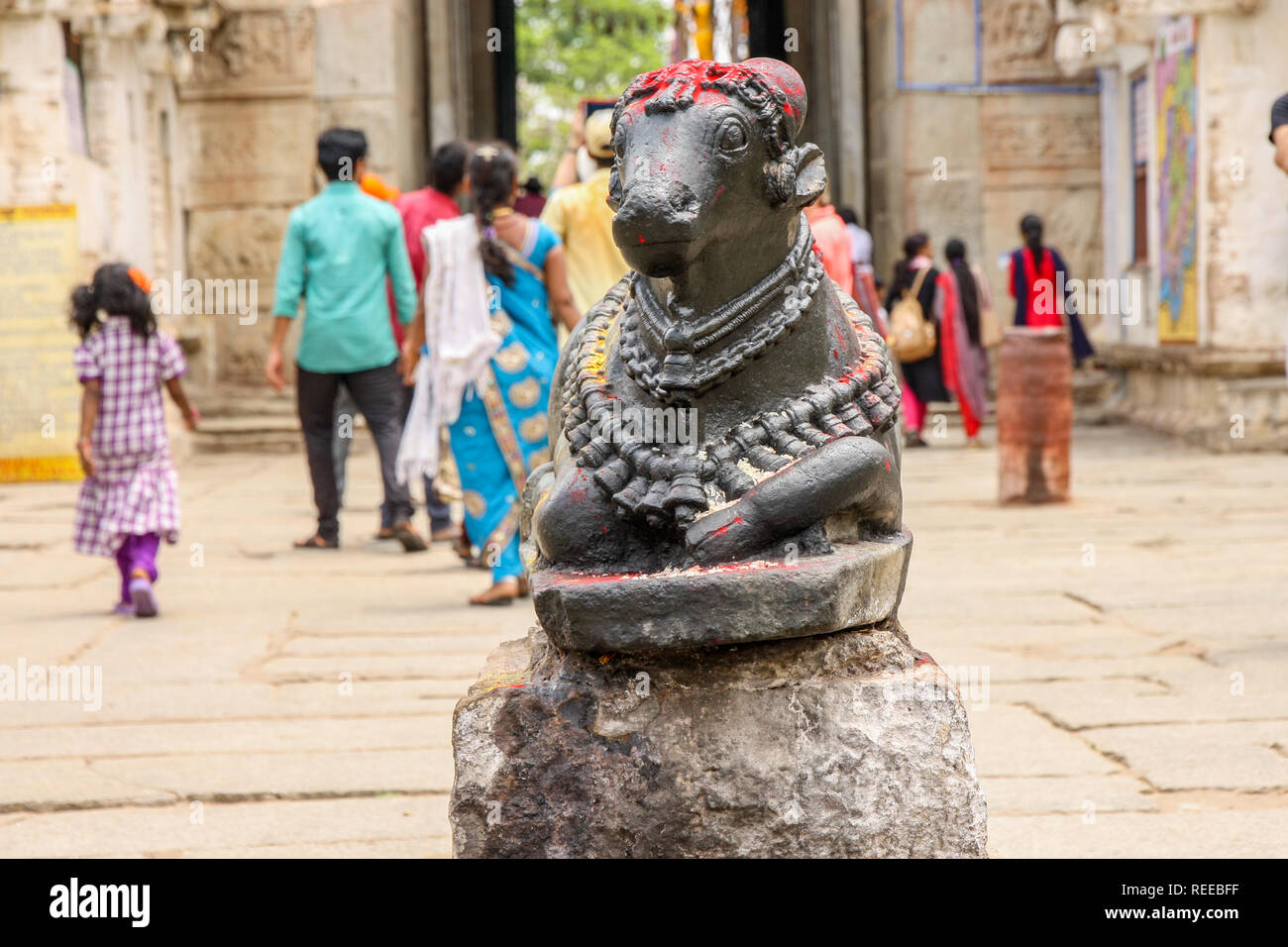 Nandi bull in a temple in Hampi, Karnataka, India with tourists in the