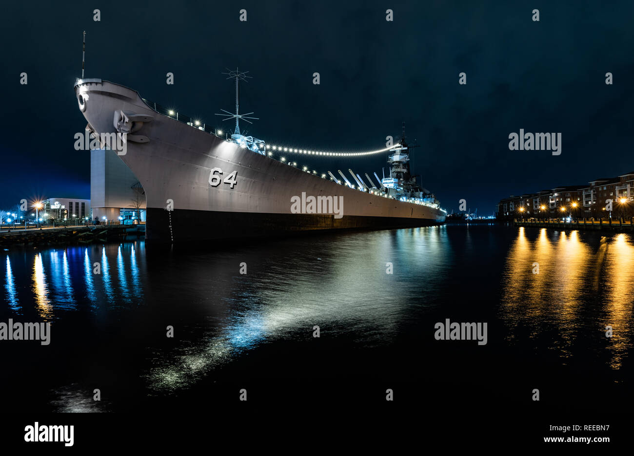 The USS Wisconsin Battleship with lights reflecting at night Stock Photo