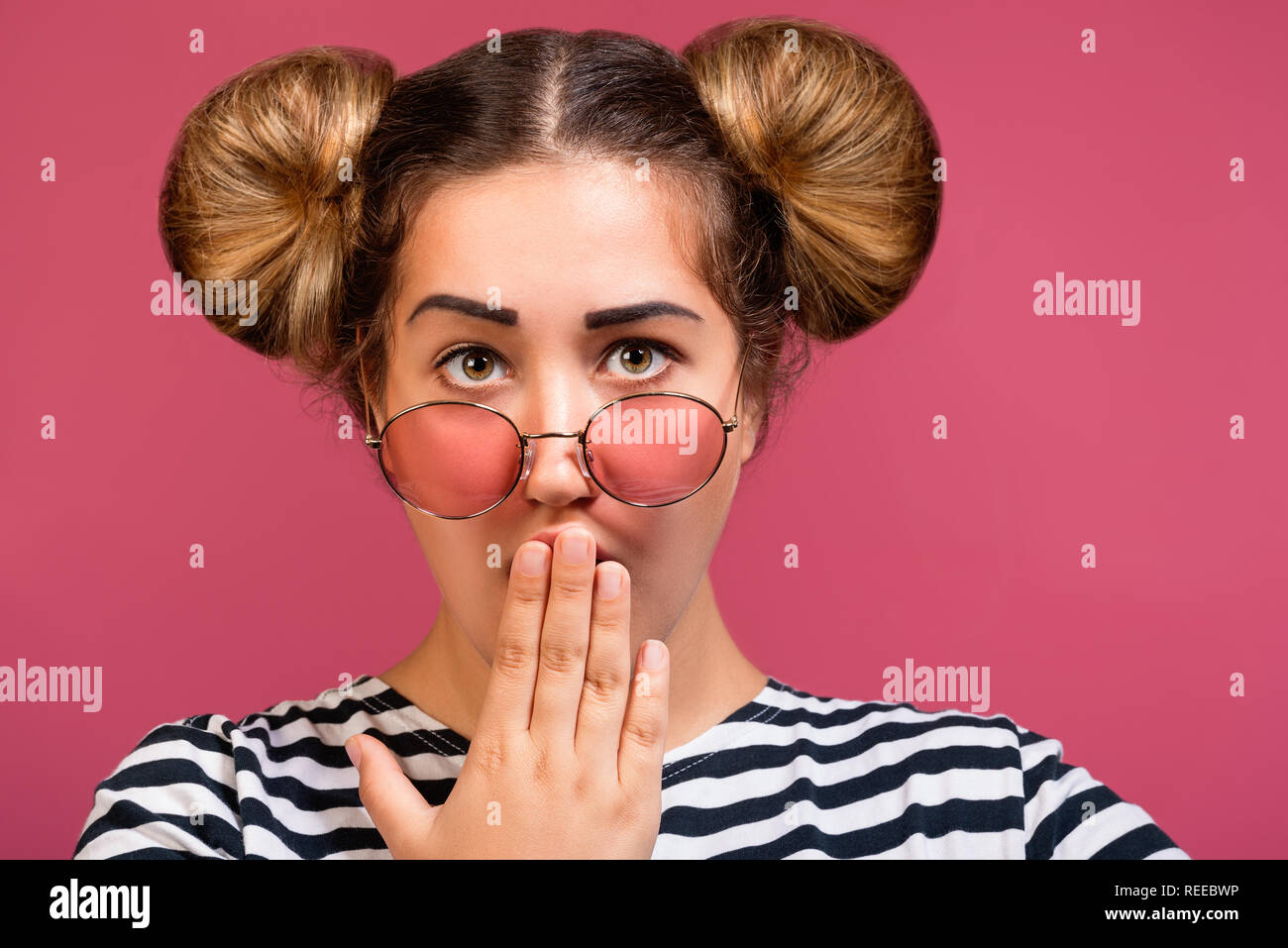 Surprised hipster girl with sunglasses and funny hairstyle covering