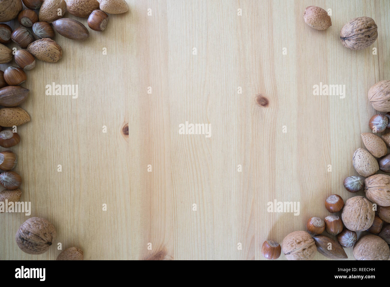 Autumnal border with nuts and an wood background Stock Photo