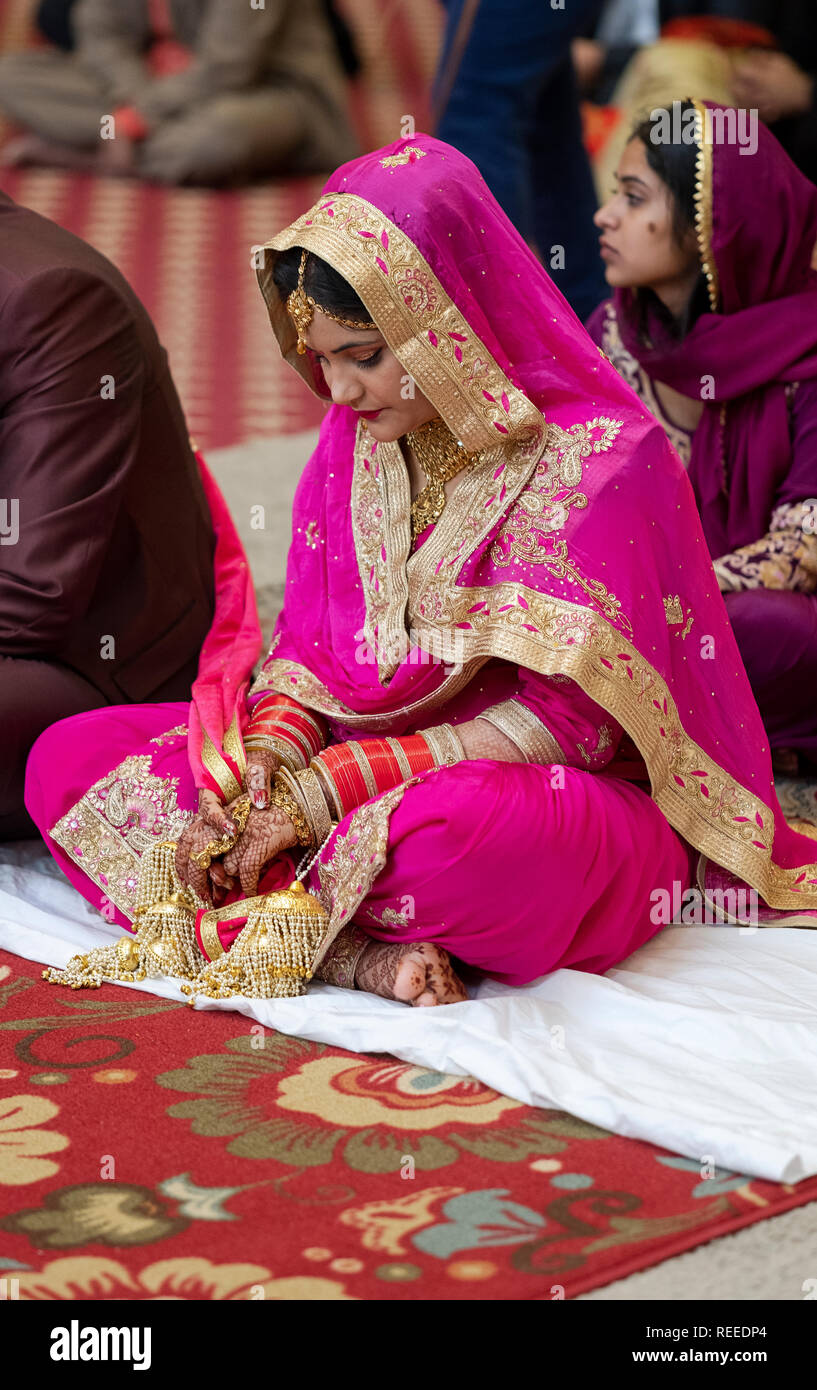 A Sikh bride seated during her wedding ceremony in a Sikh temple in Richmond Hill, Queens, New York City. Stock Photo