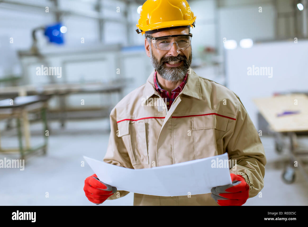 Handsome mature engineer looking at a plan in the factory Stock Photo