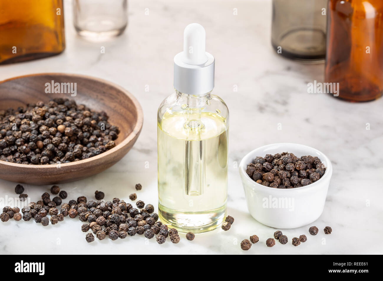 Black pepper essential oil. Black pepper oil glass bottle for beauty, skin care, wellness and medicinal purposes. Piper nigrum oil Stock Photo