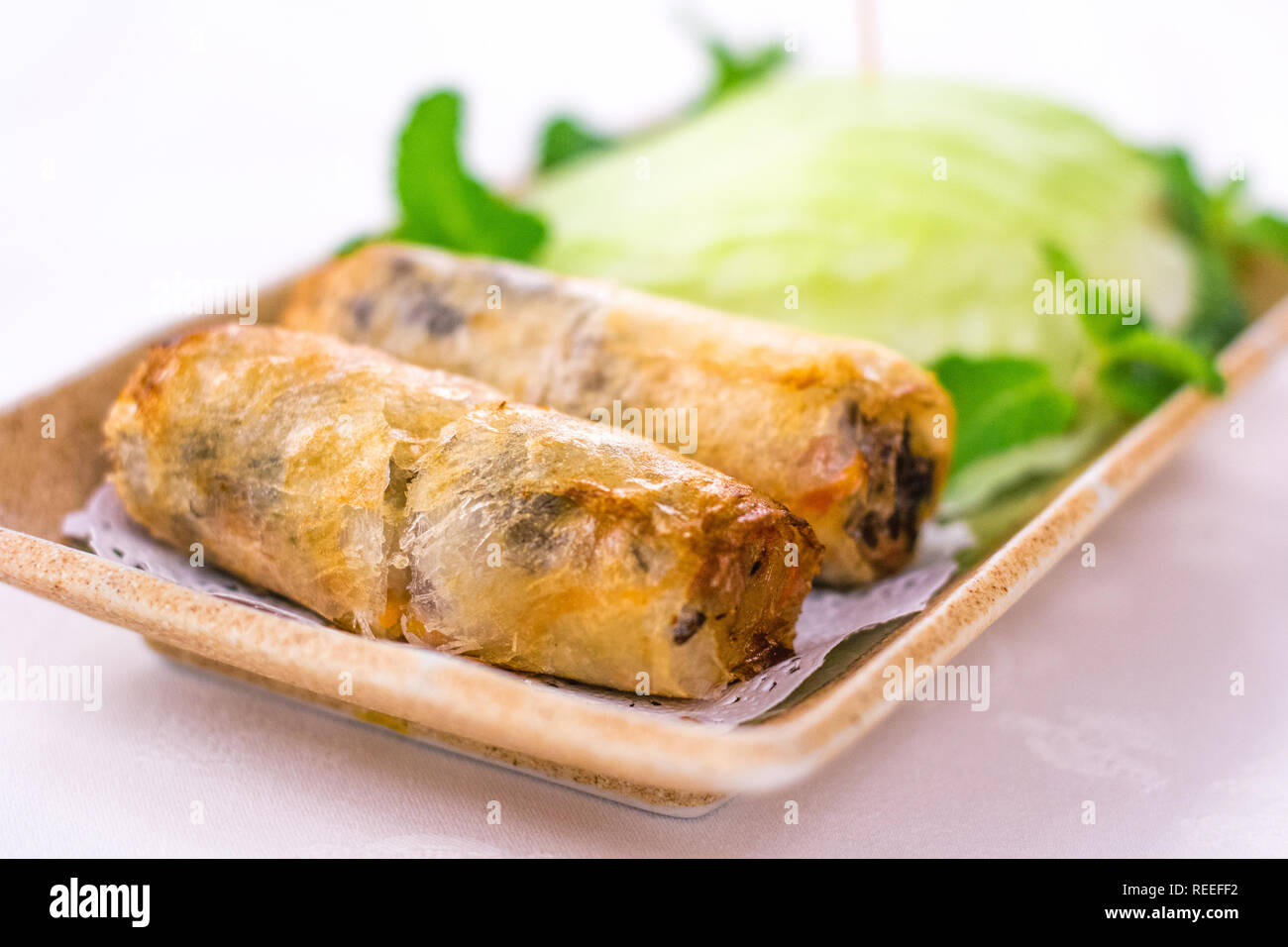 Deep fried Vietnamese Spring Rolls wrapped by fresh lettuce Stock Photo