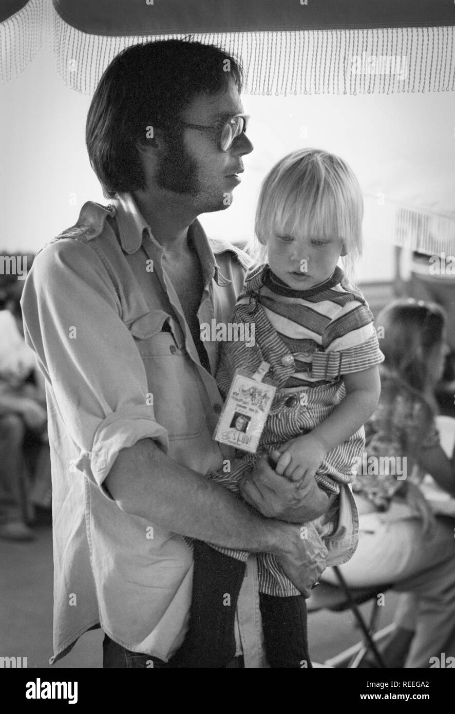 OAKLAND, USA - JULY 14: Neil Young with child Amber posed backstage at Oakland Stadium, California on July 14 1974 during the Crosby, Stills, Nash & Young 1974 US Tour (photo by Gijsbert Hanekroot) Stock Photo