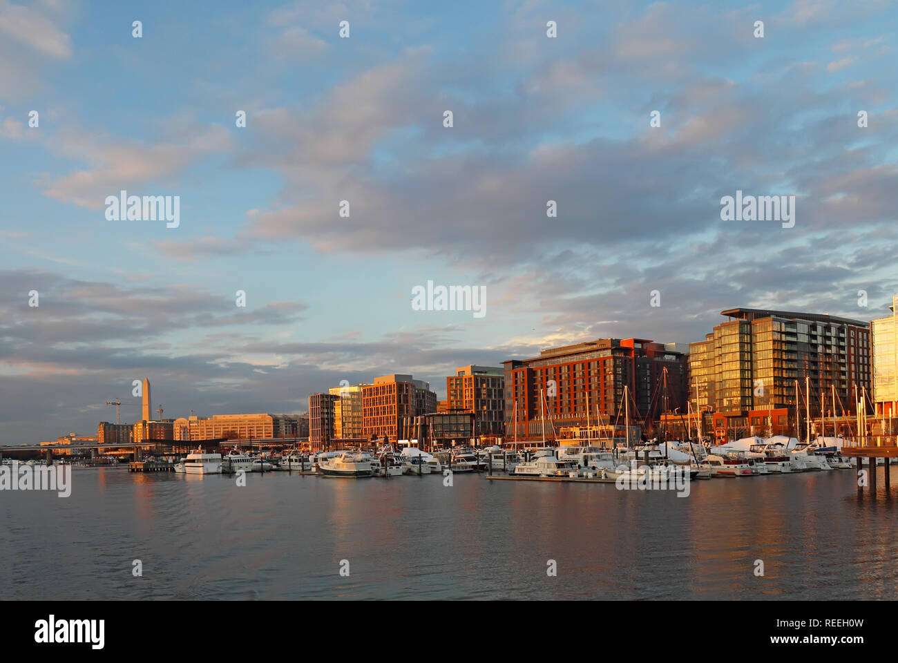 Boats and skyline of buildings at the newly redeveloped Southwest Waterfront area of Washington, DC at sunset viewed from the water in fall with the W Stock Photo