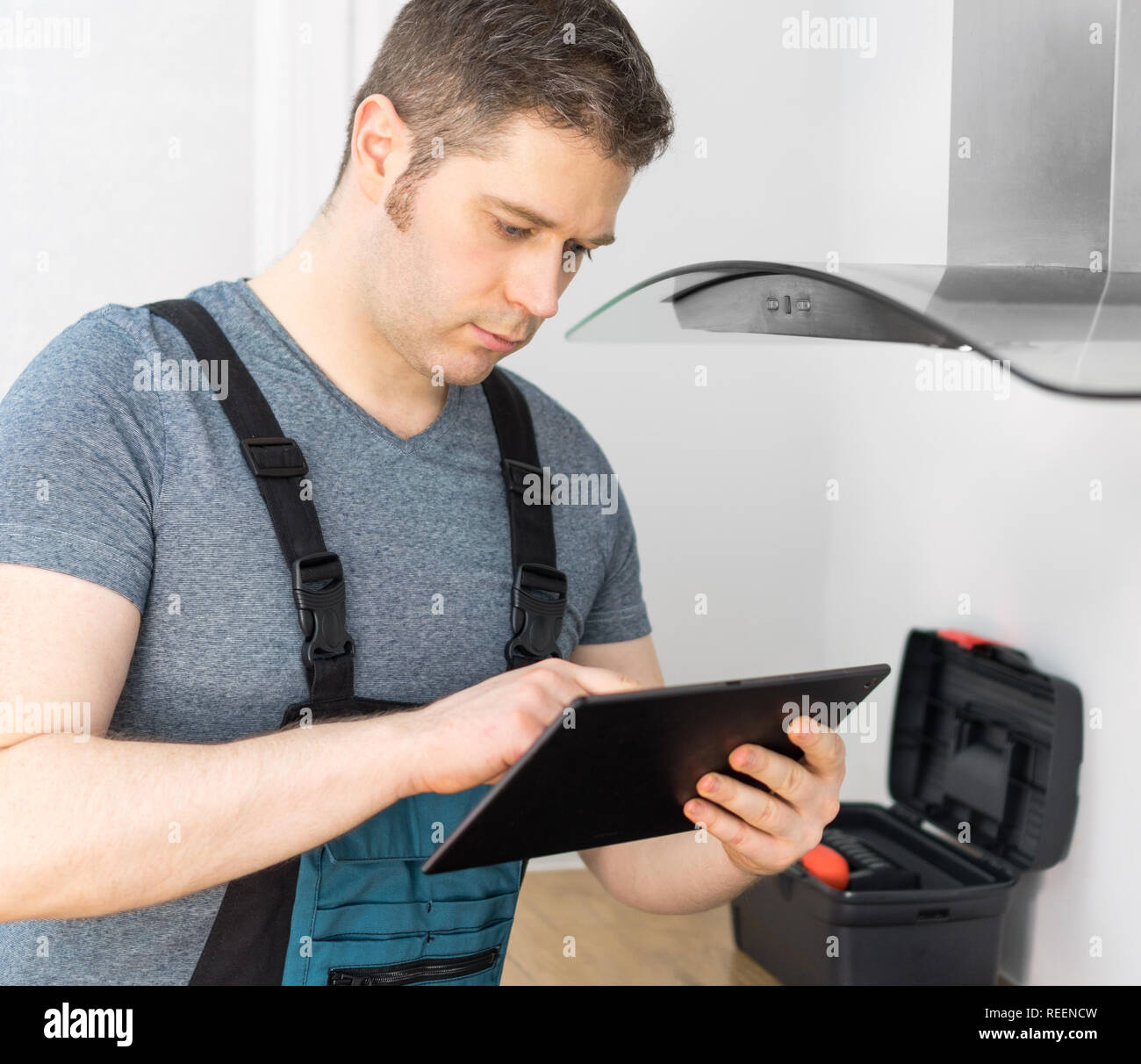 Handyman doing inspection of exhaust hood in the kitchen Stock Photo