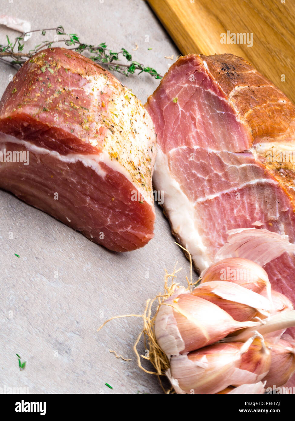 Smoked ham, jerky corned beef on table with garlic, thyme herb Natural