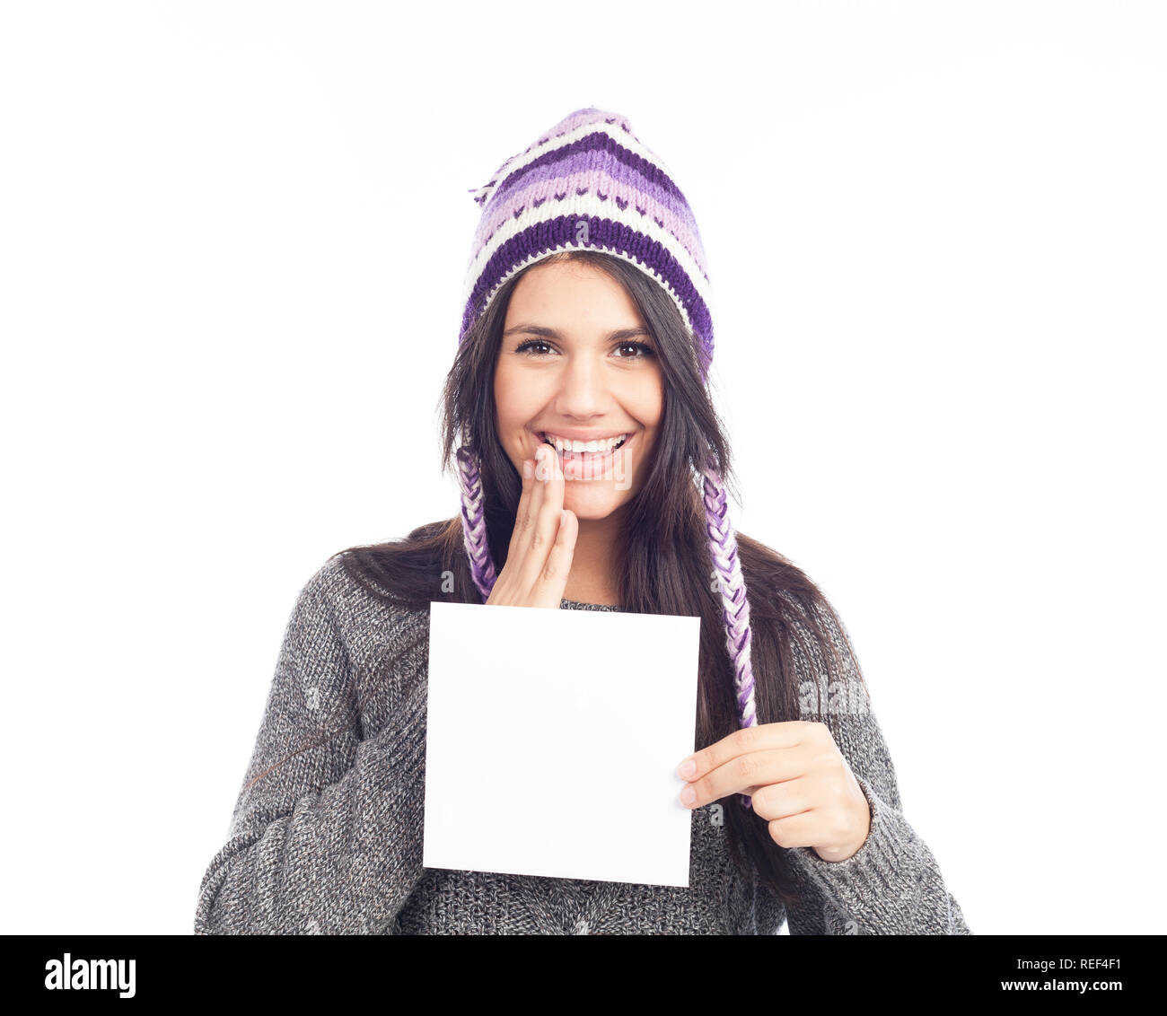 portrait of young woman with a sweater and Peruvian hat woolen holding sign card . white background . isolated Stock Photo