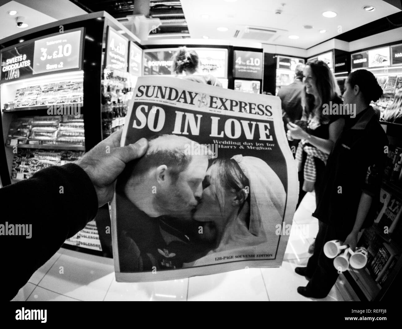 LONDON, ENGLAND - MAY 20, 2018: POV Sunday Express front cover newspaper in British press kiosk featuring portraits of Prince Harry and Meghan Markle following the Royal Wedding So in love  Stock Photo
