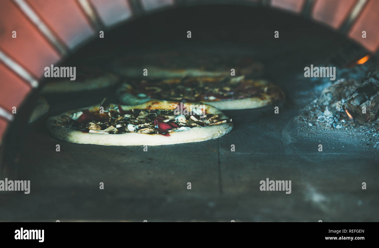Baking pizzas with cheese and meat in pizza wood oven Stock Photo Alamy