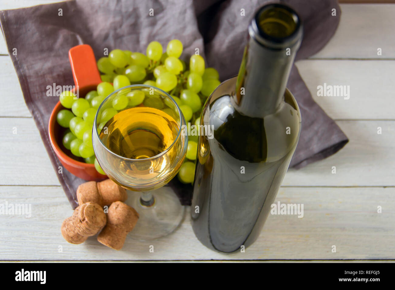 wine glass, green grapes on plate on table Stock Photo
