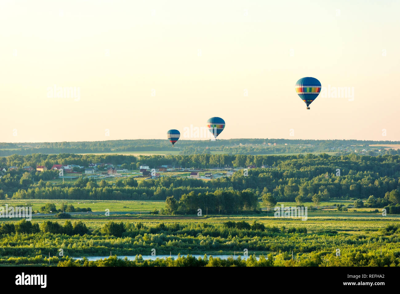 Flying in a balloon. Three balls flying on the green fields and forest Stock Photo