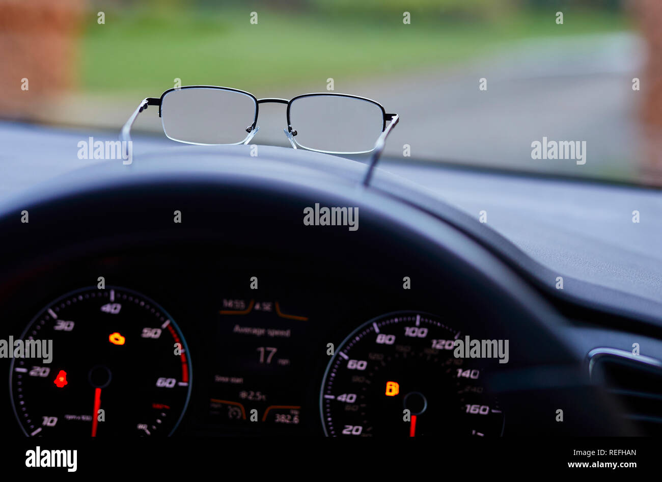 Pair of glasses on dashboard of car Stock Photo