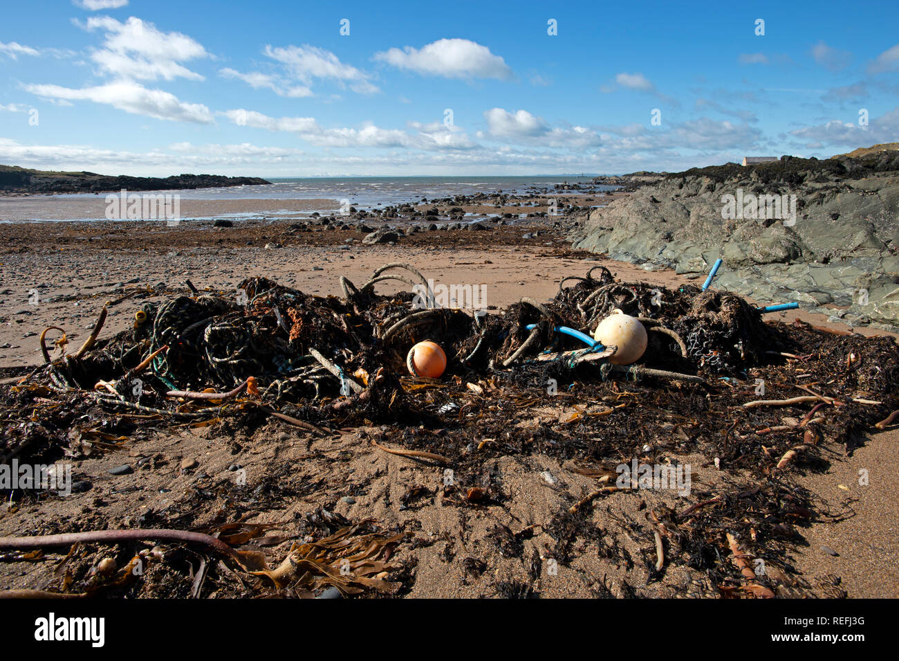 Beach pollution plastics tyres and ropes washed up on a beach in Elie Fife Scotland Stock Photo