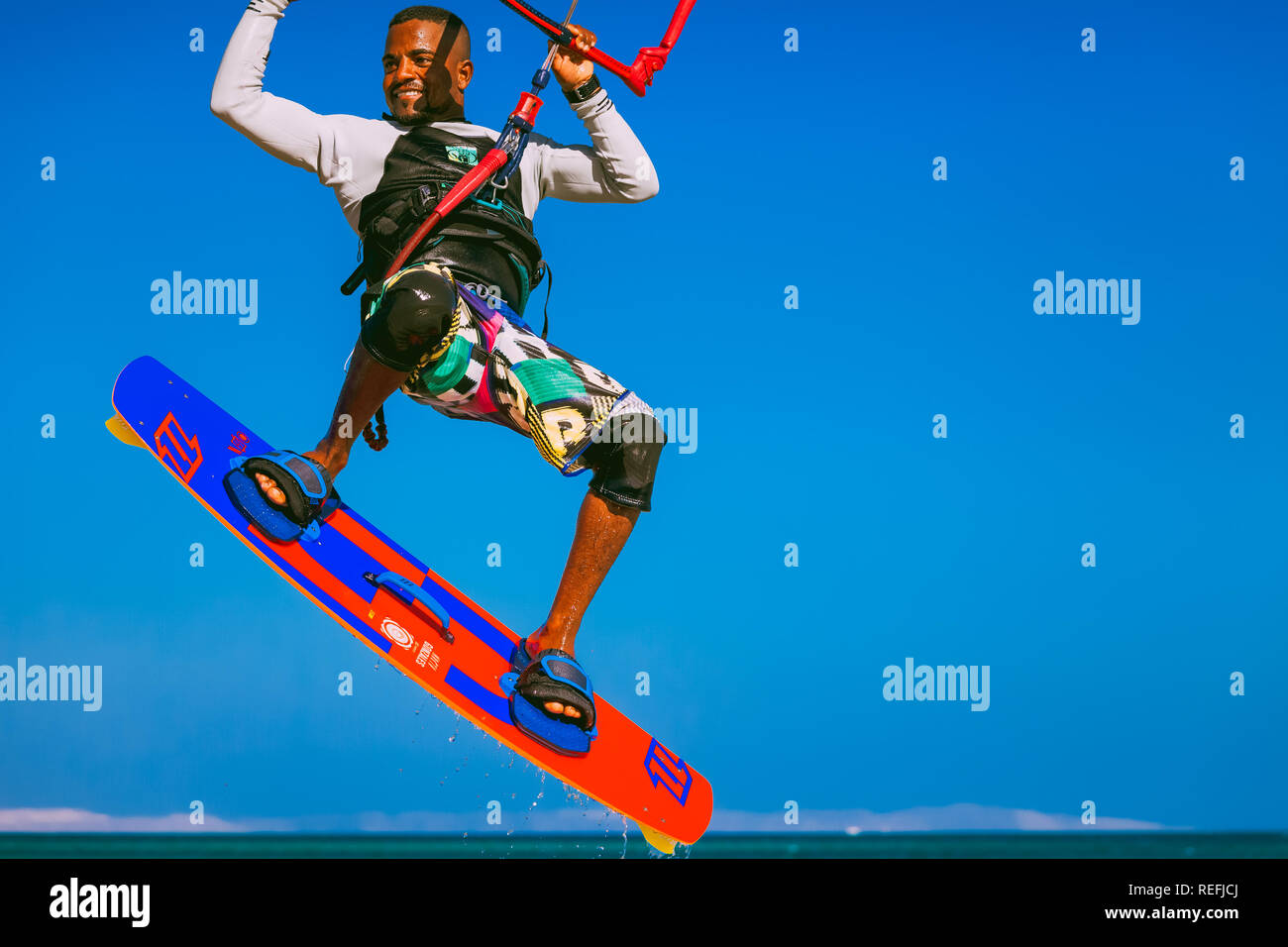Egypt, Hurghada - 30 November, 2017: The kitesurfer soaring over the Red sea surface. Close-up sportsman fully equipped with the board and kite elemen Stock Photo