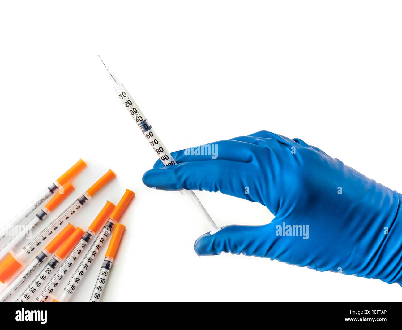 Doctor's hand in blue medical glove holding syringe with medical
