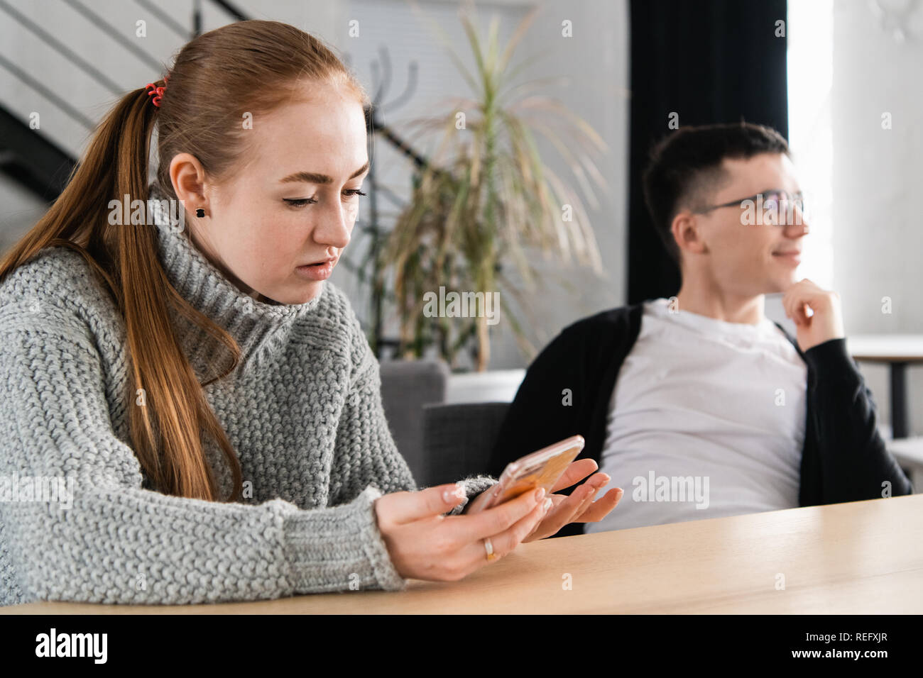 Woman reading her man's cheating messages on his phone Stock Photo