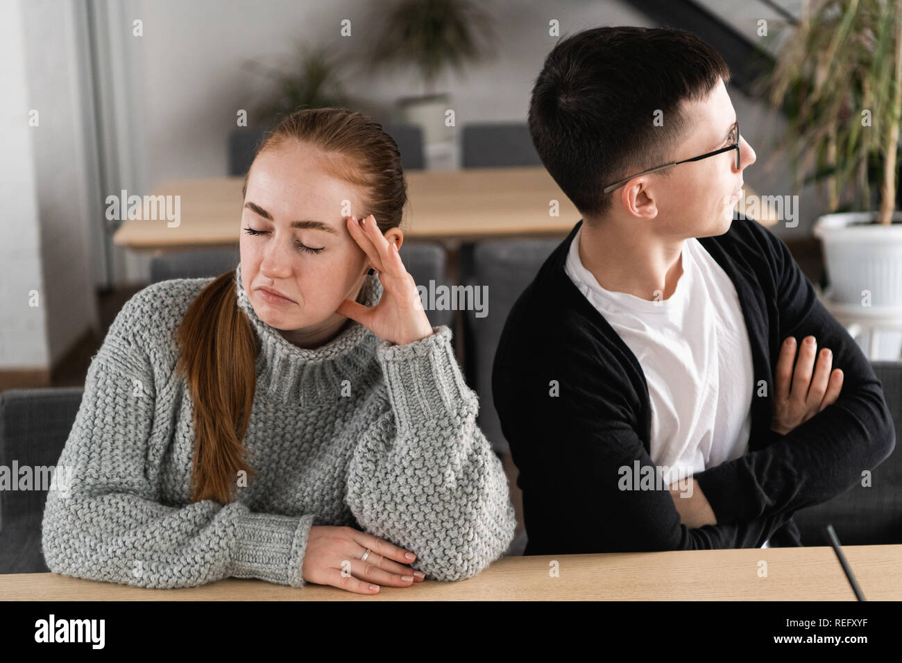 Bad relationship concept. Man and woman in disagreement. Young couple after quarrel sitting next to each other. Outdoor Stock Photo
