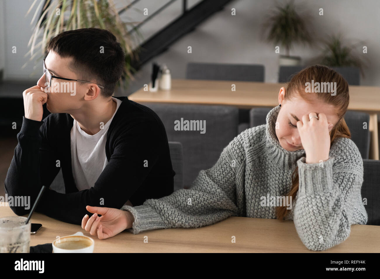 Angry unhappy young couple ignoring not looking at each other after family fight or quarrel, upset thoughtful spouses avoiding talk, sitting silently on couch, having relationship troubles Stock Photo