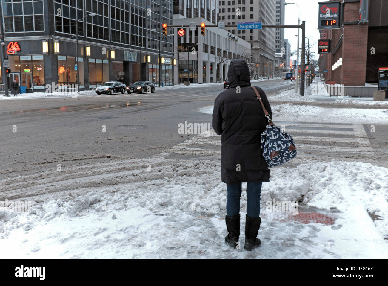 Cleveland, Ohio, USA, 21st January, 2019.  Cold weather grips the midwest as winter storm Harper leaves but followed by the coldest temperatures of the winter season.  A woman stands at East 9th Street and Superior Avenue during morning rush hour where across the street the temperature reads 11f.  Credit: Mark Kanning/Alamy Live News. Stock Photo