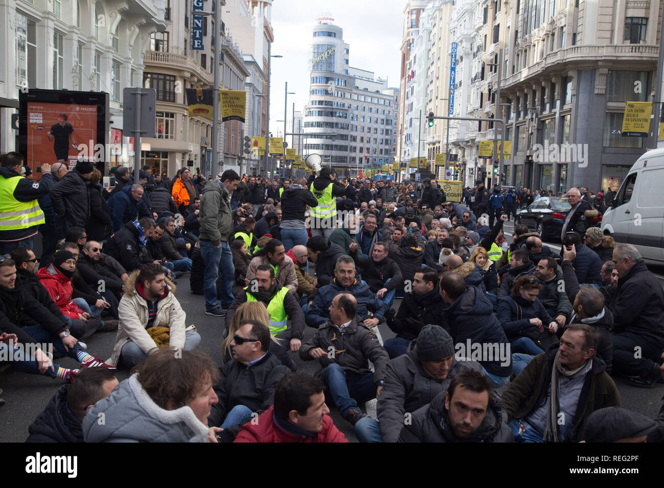 Madrid, Spain. 21st Jan, 2019. Taxi drivers seen seated on the ground at Gran Via during the strike.Hundreds of taxi drivers started an indefinite strike to pressure the Administrations in the regulation of transport vehicles with driver Credit: Lito Lizana/SOPA Images/ZUMA Wire/Alamy Live News Stock Photo