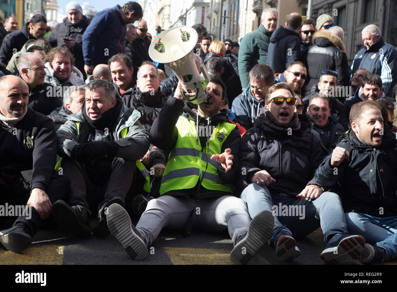 Madrid, Spain. 21st Jan, 2019. A taxi driver seen shouting on a megaphone seated on the ground with his colleagues at Gran Via during the strike.Hundreds of taxi drivers started an indefinite strike to pressure the Administrations in the regulation of transport vehicles with driver Credit: Lito Lizana/SOPA Images/ZUMA Wire/Alamy Live News Stock Photo