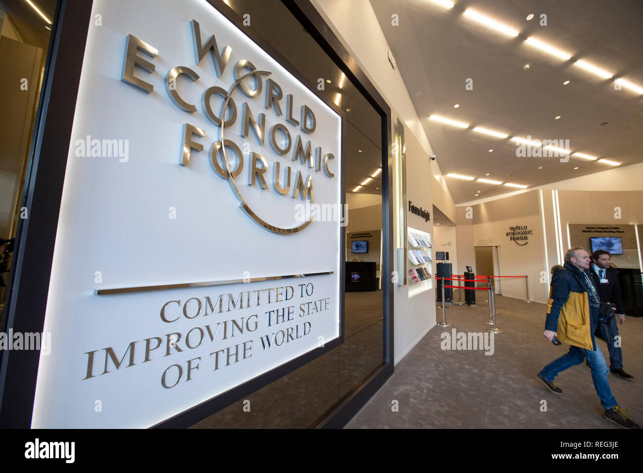 Davos, Switzerland. 21st Jan, 2019. People walk by the logo of the World Economic Forum (WEF) in Davos, Switzerland, Jan. 21, 2019. The WEF Annual Meeting will kick off in Davos on Tuesday. Credit: Xu Jinquan/Xinhua/Alamy Live News Stock Photo