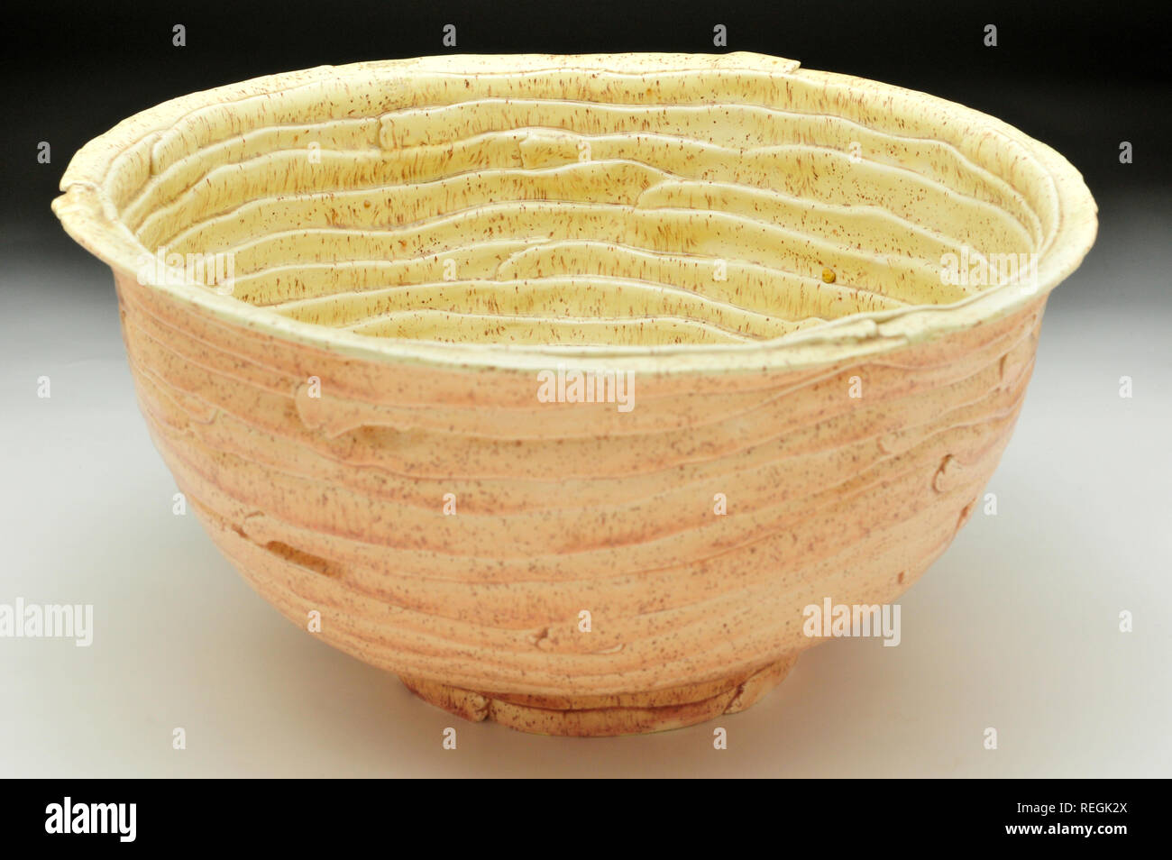 Peach and mellow yellow speckled ceramic glazed bowl Stock Photo