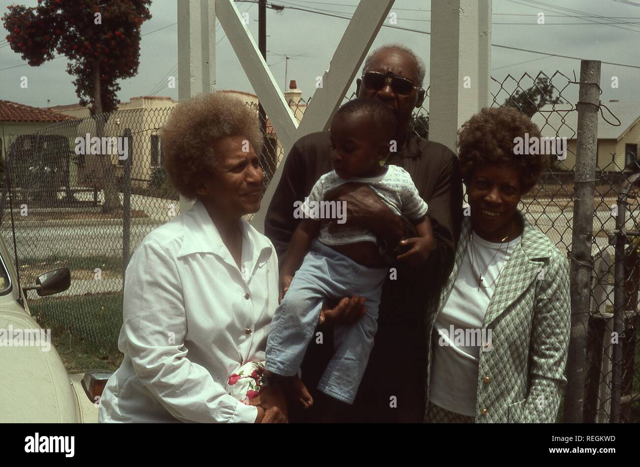 Portrait of an African American man holding a toddler and posing with ...
