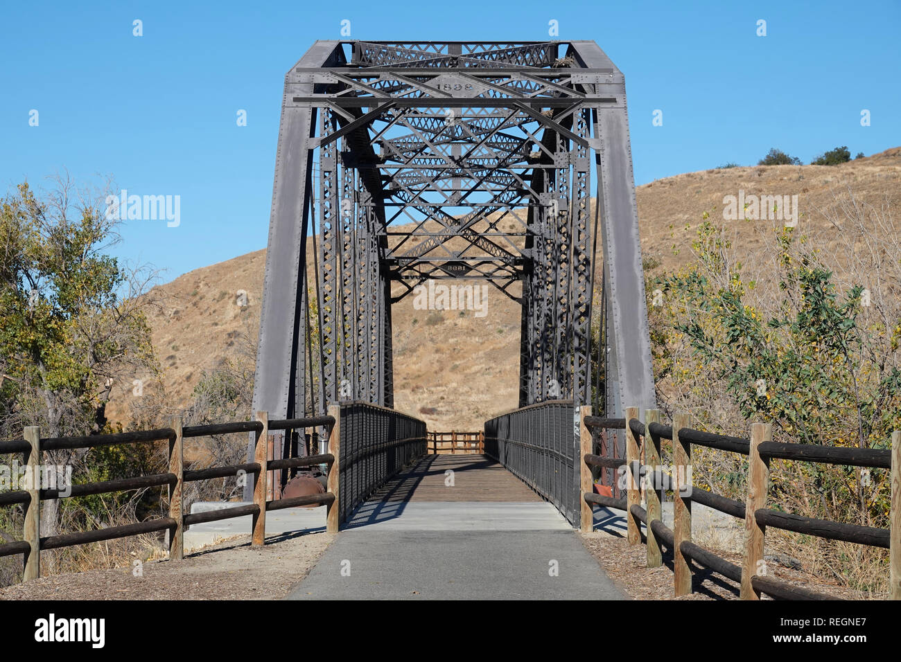 An old train bridge, built in 1898, is shown after being converted to the trailhead of a pedestrian and bike trail pathway. Stock Photo