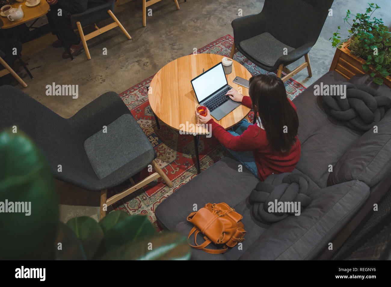 woman sitting in cafe using laptop drinking tea. white screen. copy ...